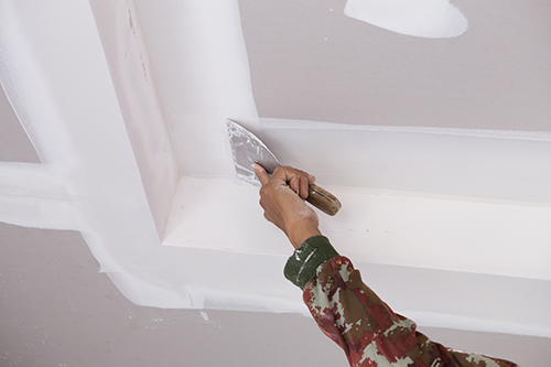 hand-worker-using-gypsum-plaster-ceiling-joints
